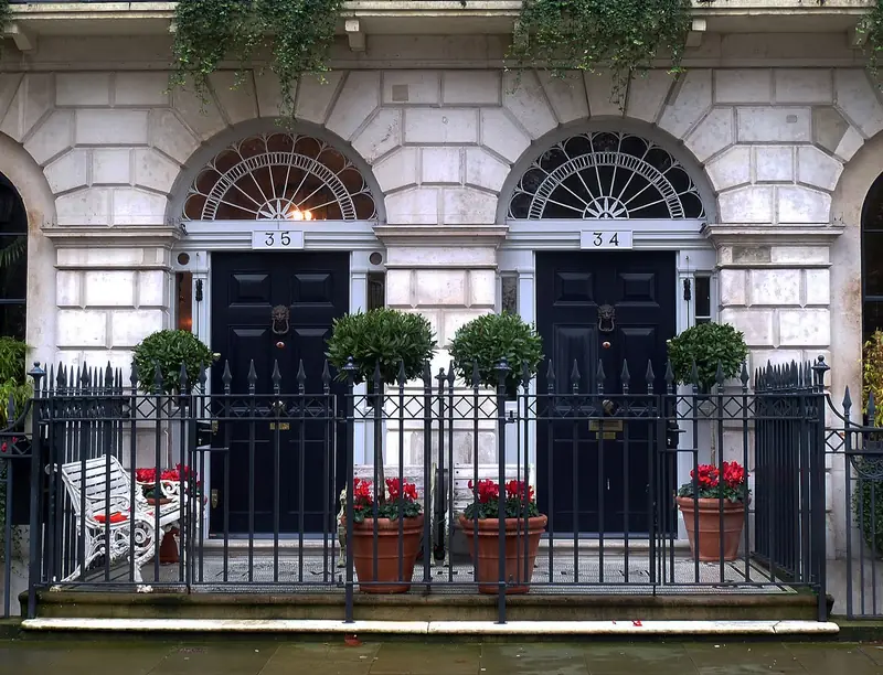 Two black Georgian front doors behind railings