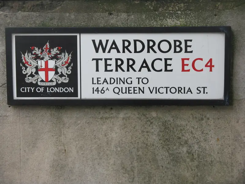 A white enamel City of London street-name plate on a stone wall
